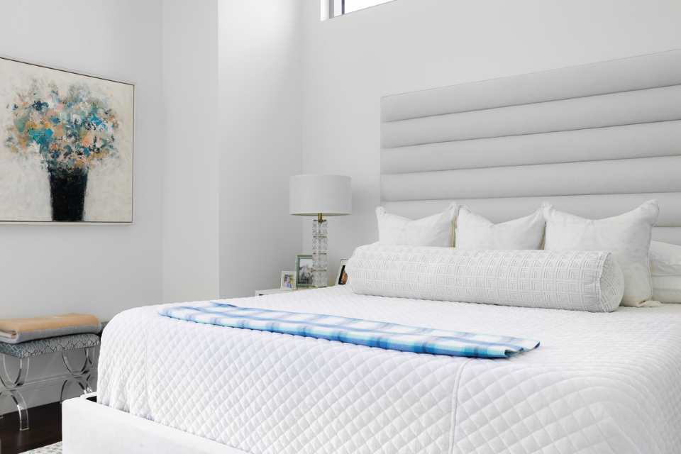 white bedroom in primary suite with abstract flower artwork